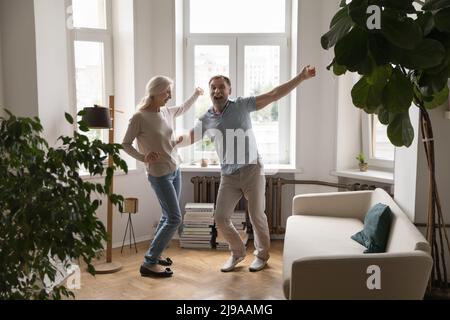 Felice coppia anziana eccitato ballare insieme alla musica Foto Stock