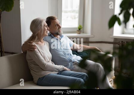 Felice coppia in pensione che riposa sul divano insieme a casa Foto Stock