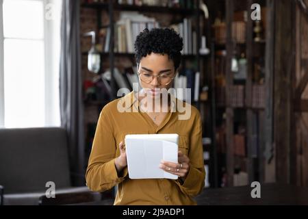 Donna africana seria focalizzata sul tavolo digitale Foto Stock
