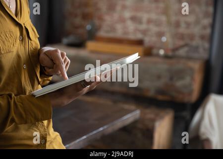 Vista ritagliata la donna d'affari africana usa il tablet digitale che lavora in ufficio Foto Stock