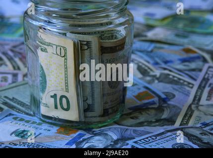 Dollari in vaso di vetro contro sfondo di soldi Foto Stock