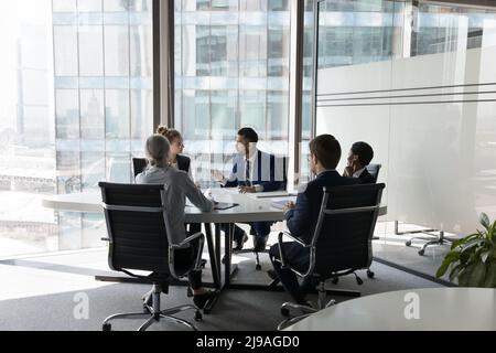 Cinque uomini d'affari multietnici che negoziano in una moderna sala riunioni Foto Stock