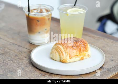 Croissant, croissant alla francese o croissant al cioccolato o pane e caffè e succo di limone per servire Foto Stock