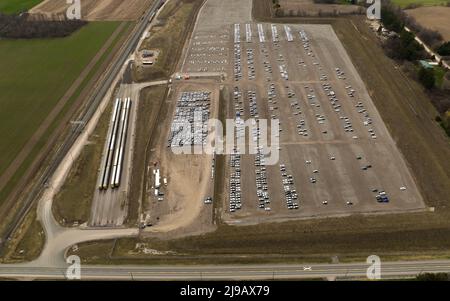 Una vista drone accanto a un centro di distribuzione e omologazione automatica. I treni AutoTrack si trovano accanto al grande centro, accanto alla ferrovia. Foto Stock