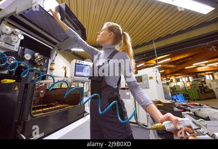 Una tirocinante femminile riceve lezioni tecniche dal suo istruttore. Entrambe le donne lavorano come ingegneri computerizzati di controllo numerico. Foto Stock