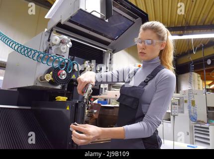 Una tirocinante femminile riceve lezioni tecniche dal suo istruttore. Entrambe le donne lavorano come ingegneri computerizzati di controllo numerico. Foto Stock