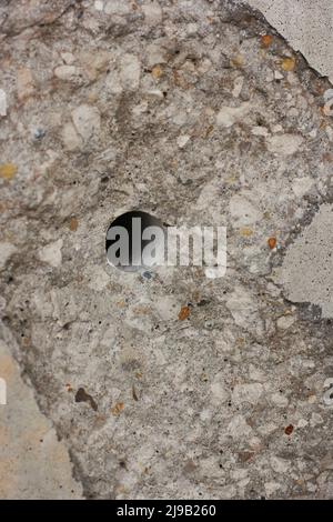 Un foro forato nel blocco di calcestruzzo industriale. Foto Stock