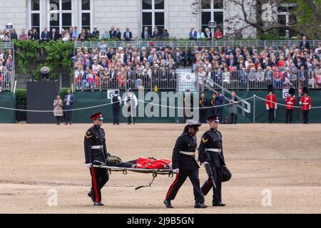 Un membro delle Guardie irlandesi svenisce oggi sotto l’alta temperatura durante la revisione del generale maggiore di Trooping the Color alla Horse Guards Parade Foto Stock