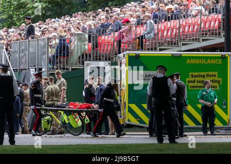 Un membro delle Guardie irlandesi svenisce oggi sotto l’alta temperatura durante la revisione del generale maggiore di Trooping the Color alla Horse Guards Parade Foto Stock