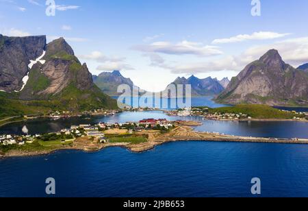 Villaggio di pescatori Reine circondato da alte montagne e fiordi sulle isole Lofoten Foto Stock