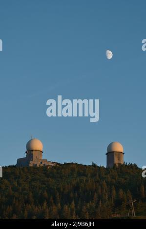 Le due torri sul monte Großer Arber all'ora blu con la luna sopra. Parte di Lamer Winkel, Foresta Bavarese, Palatinato superiore, Baviera, Germania. Foto Stock