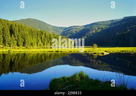 Bellissimo lago Kleiner Arbersee con le sue isole balneari nella Foresta Bavarese. Vista sul monte Großer Arber con le sue due torri. Palatinato superiore, Ba Foto Stock