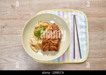 Fettine fritte di salsa di pepe di Sichuan di maiale e cavolo con broccoli sul piatto Foto Stock