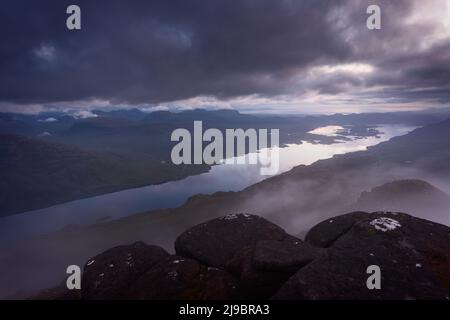 Vista su Loch Maree, Torridon, Scozia al crepuscolo, mentre le nuvole passano proprio sotto la sommit di Slioch Foto Stock