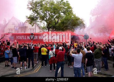 I tifosi di Liverpool si illuminano mentre si riuniscono all'esterno per guardare il bus di squadra arrivare prima della partita della Premier League ad Anfield, Liverpool. Data foto: Domenica 22 maggio 2022. Foto Stock