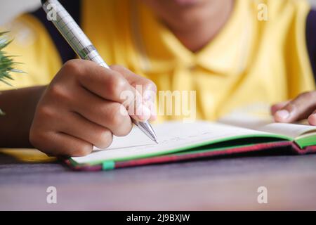 la scrittura della mano del bambino sul blocco note shile sited Foto Stock