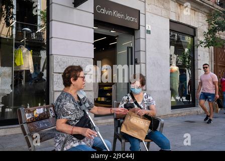 Un acquirente è visto seduto su una panca pubblica come lei tiene una borsa della donna portoghese accessori marchio parfois di fronte al marchio di moda multinazionale americana, Calvin Klein Jeans (CKJ) negozio in Spagna (Foto di Xavi Lopez / SOPA Images / Sipa USA) Foto Stock