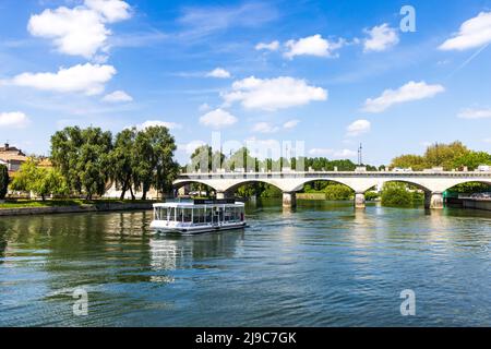 Cognac, Francia - 25 aprile 2022: Fiume Charente con barca da crociera sul fiume Hennesy per i turisti al ponte di ingresso Cognac in Charente Francia Foto Stock