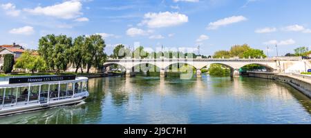 Cognac, Francia - 25 aprile 2022: Fiume Charente con barca da crociera sul fiume Hennesy per i turisti al ponte di ingresso Cognac in Charente Francia Foto Stock