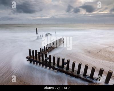 Onde che si lavano su un groyne di legno a Caister-on-Sea a Norfolk. Foto Stock