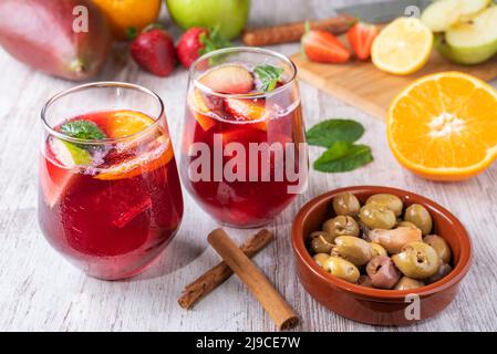 Due bicchieri con sangria, una tipica bevanda spagnola, accompagnati da olive. In background. Foto Stock