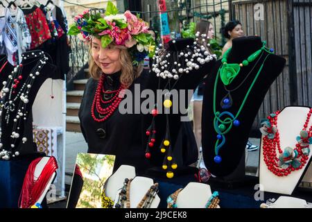 Donna in fascia fiorita che vende gioielli e accessori ucraini al St. George Ukrainian Greek Catholic Church Festival di New York nel 2022 Foto Stock