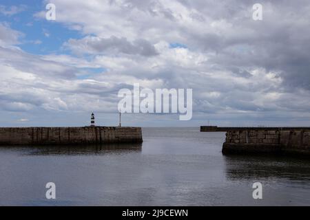 Iconico faro Seaham a righe sul molo con nuvole e pareti marine Foto Stock