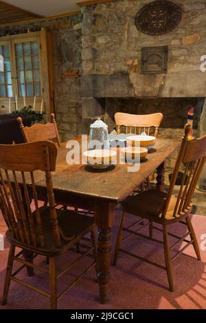 Terracotta colorata su un tavolo antico con sedie a schienale alto nella sala da pranzo all'interno di una vecchia casa in stile cottage Canadiana del 1733 circa. Foto Stock