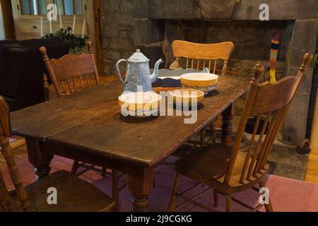 Terracotta colorata su un tavolo antico con sedie a schienale alto nella sala da pranzo all'interno di una vecchia casa in stile cottage Canadiana del 1733 circa. Foto Stock