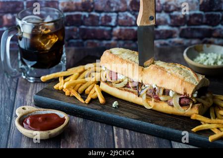 Un sandwich di hoagie con bistecca e formaggio blu servito con patatine fritte e cola. Foto Stock