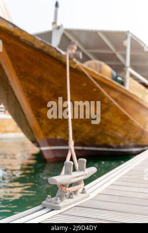 Dhow tradizionale del Qatar legato su un molo di metallo o su un palo di ormeggio in acciaio su un molo Foto Stock