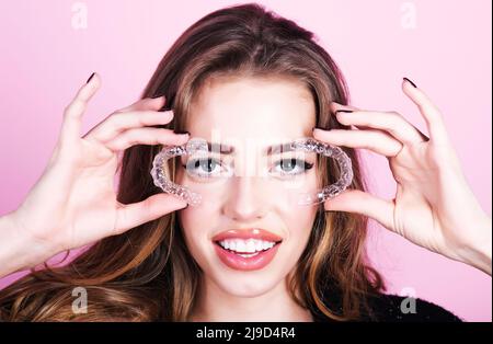 Ragazza con fermo allineatore invisibile. Correzione dentale. Dispositivo ortodontico. Corso di trattamento dei denti. Foto Stock