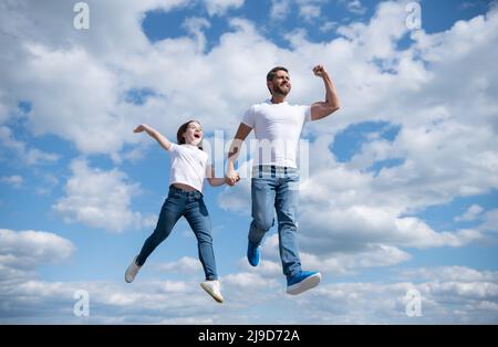 felice padre e figlia saltare in cielo. libertà Foto Stock