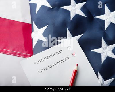 Matita rossa, voto a scrutinio sullo sfondo della bandiera americana di stato. Vista ad angolo basso. Non ci sono persone nella foto. Elezioni, votazioni, dibattiti, Foto Stock