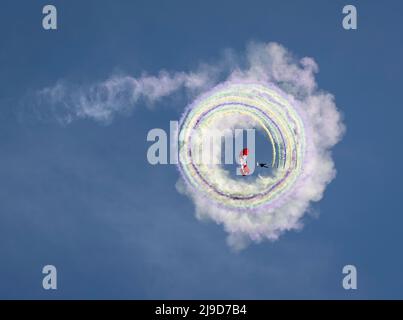 Un membro del Canadian Armed Forces Parachute Team, The Skyhawks, gira cerchi con generatori di fumo multipli sopra Victoria, British Columbia, CAN Foto Stock