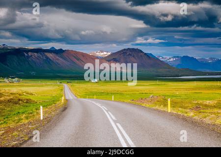 Strada vuota che conduce lungo la costa. Paesaggio tipico islandese. Popolare attrazione turistica. Giornata drammatica e scena pittoresca. Ubicazione luogo isola Foto Stock