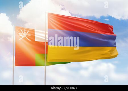 Cielo azzurro soleggiato e bandiere di armenia e oman Foto Stock