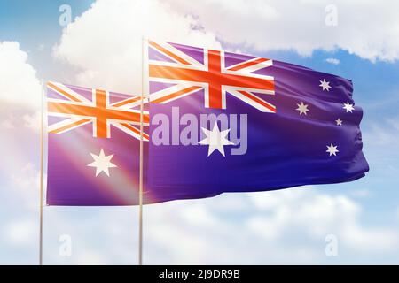 Cielo azzurro soleggiato e bandiere di australia e australia Foto Stock