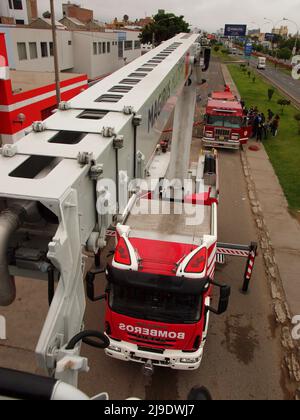 Un camion di pompiere Magirus Iveco 180E28 dal corpo generale dei pompieri volontari del Perù - CGBVP - estendendo la sua gru telescopica Foto Stock