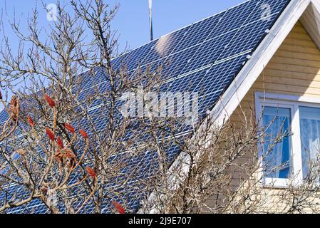 Casa singola familiare con impianto solare o fotovoltaico. Pannelli solari sul tetto della casa Foto Stock