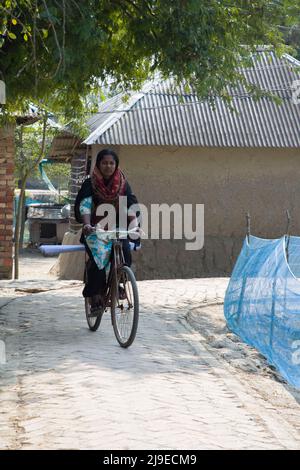 Un'ONG del Bangladesh che viaggia attraverso il villaggio in bicicletta a Satkhira. Pedalando in bicicletta per il tabù sociale femminile nella società del Bangladesh. Foto Stock