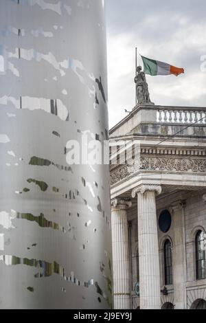 Millennium spire di Dublino su o'Connell Street con la bandiera irlandese che vola sopra il GPO Foto Stock