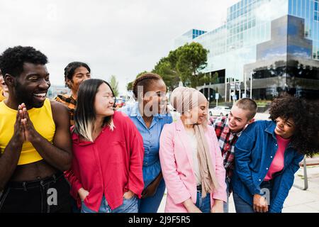 Giovani persone diverse che si divertono all'aperto ridendo insieme - Focus on asian ragazza faccia Foto Stock