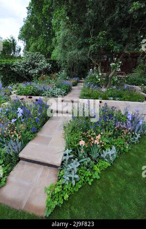 Londra, Regno Unito. 23rd maggio 2022. The Morris & Co. Garden, uno dei bellissimi giardini in mostra al 2022 Royal Horticultural Society Chelsea Flower Show, aperto oggi nel parco del Royal Hospital Chelsea a Chelsea, Londra, Regno Unito - 23 maggio 2022. Il design del giardino di Morris & Co. Reimita due modelli iconici di Morris. Il primo modello di Morris Trellis (1862) ispira la disposizione del giardino e i percorsi, mentre uno dei suoi modelli più famosi, Willow Boughs (1887), si riflette nel design del padiglione e dei canali d'acqua. Il padiglione incorpora pali a motivi geometrici Foto Stock