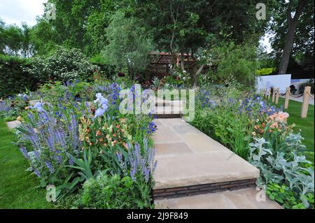 Londra, Regno Unito. 23rd maggio 2022. The Morris & Co. Garden, uno dei bellissimi giardini in mostra al 2022 Royal Horticultural Society Chelsea Flower Show, aperto oggi nel parco del Royal Hospital Chelsea a Chelsea, Londra, Regno Unito - 23 maggio 2022. Il design del giardino di Morris & Co. Reimita due modelli iconici di Morris. Il primo modello di Morris Trellis (1862) ispira la disposizione del giardino e i percorsi, mentre uno dei suoi modelli più famosi, Willow Boughs (1887), si riflette nel design del padiglione e dei canali d'acqua. Il padiglione incorpora pali a motivi geometrici Foto Stock