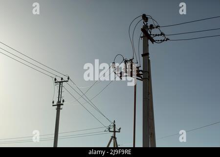 Poli con fili elettrici. Silhouette di rack di comunicazione. Linee ad alta tensione. Trasferimento di energia. Pali elettrici di calcestruzzo. Foto Stock