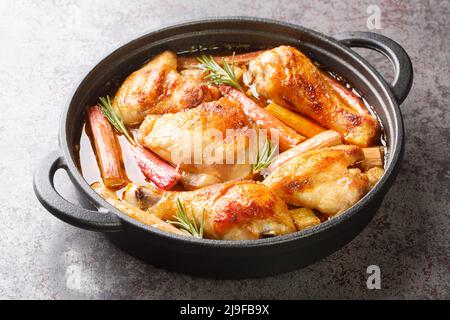 Stufato di pollo fatto in casa con rabarbaro, rosmarino e vino bianco da vicino in una padella sul tavolo. Orizzontale Foto Stock