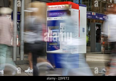 Lipsia, Germania. 23rd maggio 2022. I viaggiatori passano davanti a un distributore automatico di biglietti della Mitteldeutsche Regiobahn (MRB) alla stazione centrale di Lipsia. La gente in Sassonia potrà acquistare il biglietto da 9 euro per i mezzi pubblici a partire da lunedì. Il biglietto è di solito disponibile presso distributori automatici, punti vendita o autisti di autobus e sarà valido in tutta la nazione a partire da giugno 1. Credit: Jan Woitas/dpa/Alamy Live News Foto Stock