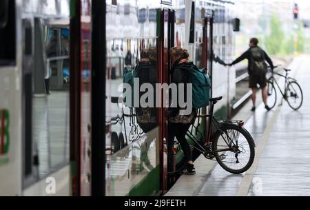 Lipsia, Germania. 23rd maggio 2022. Due viaggiatori salgono a bordo di un treno con le loro biciclette alla Stazione Centrale di Lipsia. La gente in Sassonia potrà acquistare il biglietto da 9 euro per i mezzi pubblici a partire da lunedì. Il biglietto è di solito disponibile presso distributori automatici, punti vendita o autisti di autobus e sarà valido in tutta la nazione a partire da giugno 1. Credit: Jan Woitas/dpa/Alamy Live News Foto Stock