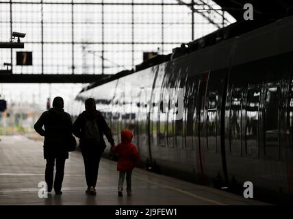 Lipsia, Germania. 23rd maggio 2022. Due donne e un bambino camminano lungo un treno alla stazione centrale di Lipsia. La gente in Sassonia potrà acquistare il biglietto da 9 euro per i mezzi pubblici a partire da lunedì. Il biglietto è di solito disponibile presso distributori automatici, punti vendita o autisti di autobus e sarà valido in tutta la nazione a partire da giugno 1. Credit: Jan Woitas/dpa/Alamy Live News Foto Stock